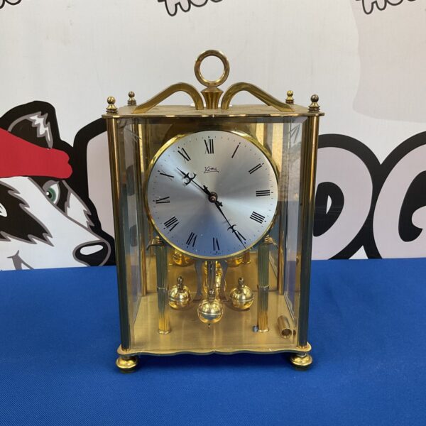 Vintage brass Koma anniversary clock on display.
