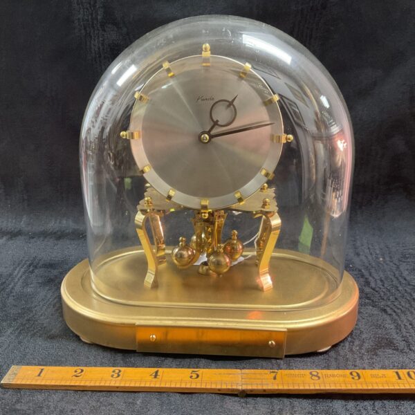 Vintage Kundo anniversary clock with glass dome and brass pendulum.