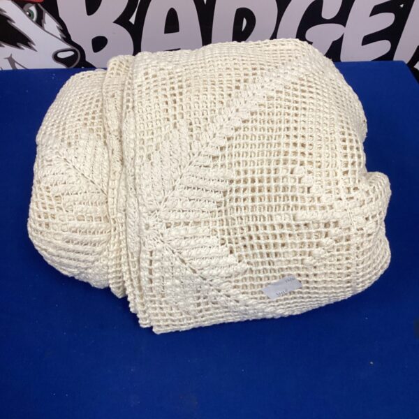 Large handmade crochet blanket with textured design.