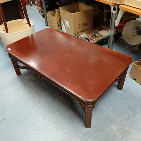 Large reproduction mahogany coffee table in a living room setting.