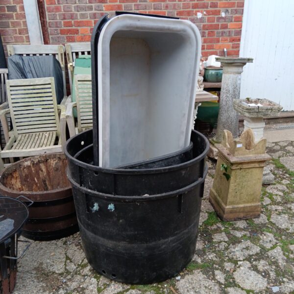 Stack of four large plastic water butts for garden use.