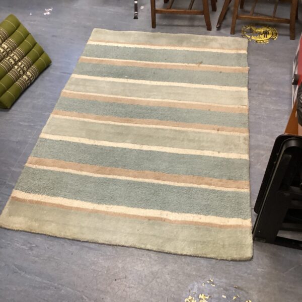Blue, brown, and cream striped Laura Ashley rug on a floor.