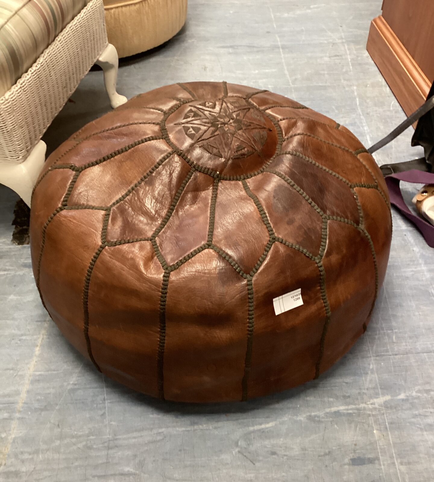 Detailed view of a handcrafted leather pouffe with intricate design.