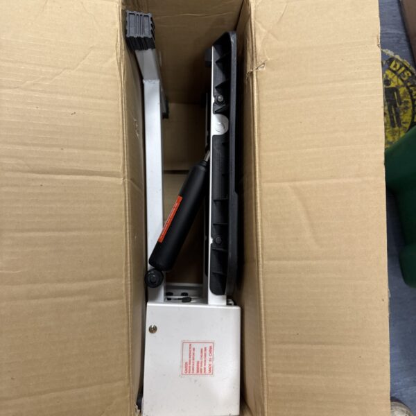 Leg exercise machine packed in cardboard box for shipping.