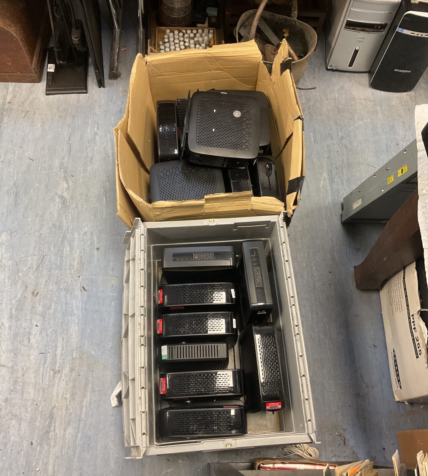 Lot of Ligel thin client computers in cardboard boxes.