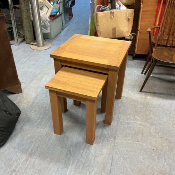 Pair of light oak nesting occasional tables in a home setting.
