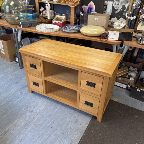 Front view of a light oak TV stand with two drawers.