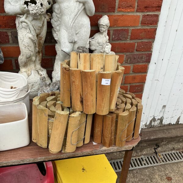 Three rolls of rustic log garden edging for landscaping.