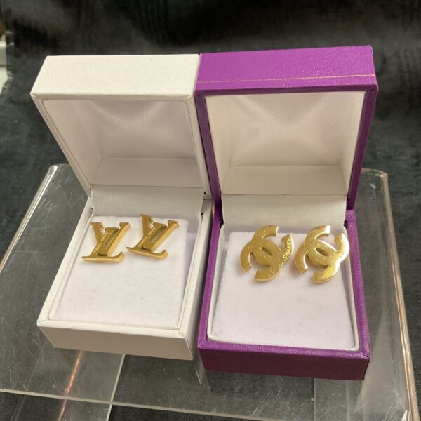 New designer stud earrings in packaging, featuring LV and CC logos.