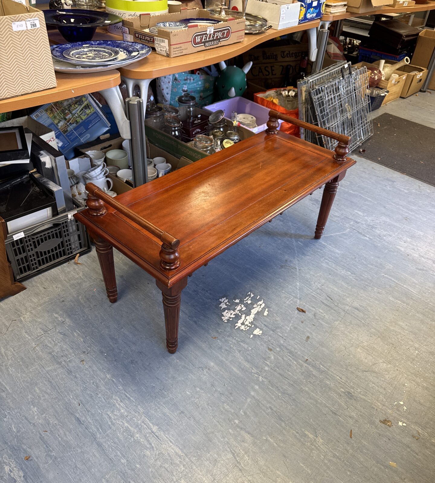 Vintage mahogany window seat with curved legs and warm tones.