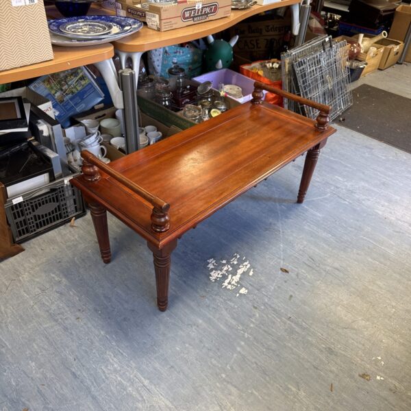 Vintage mahogany window seat with curved legs and warm tones.