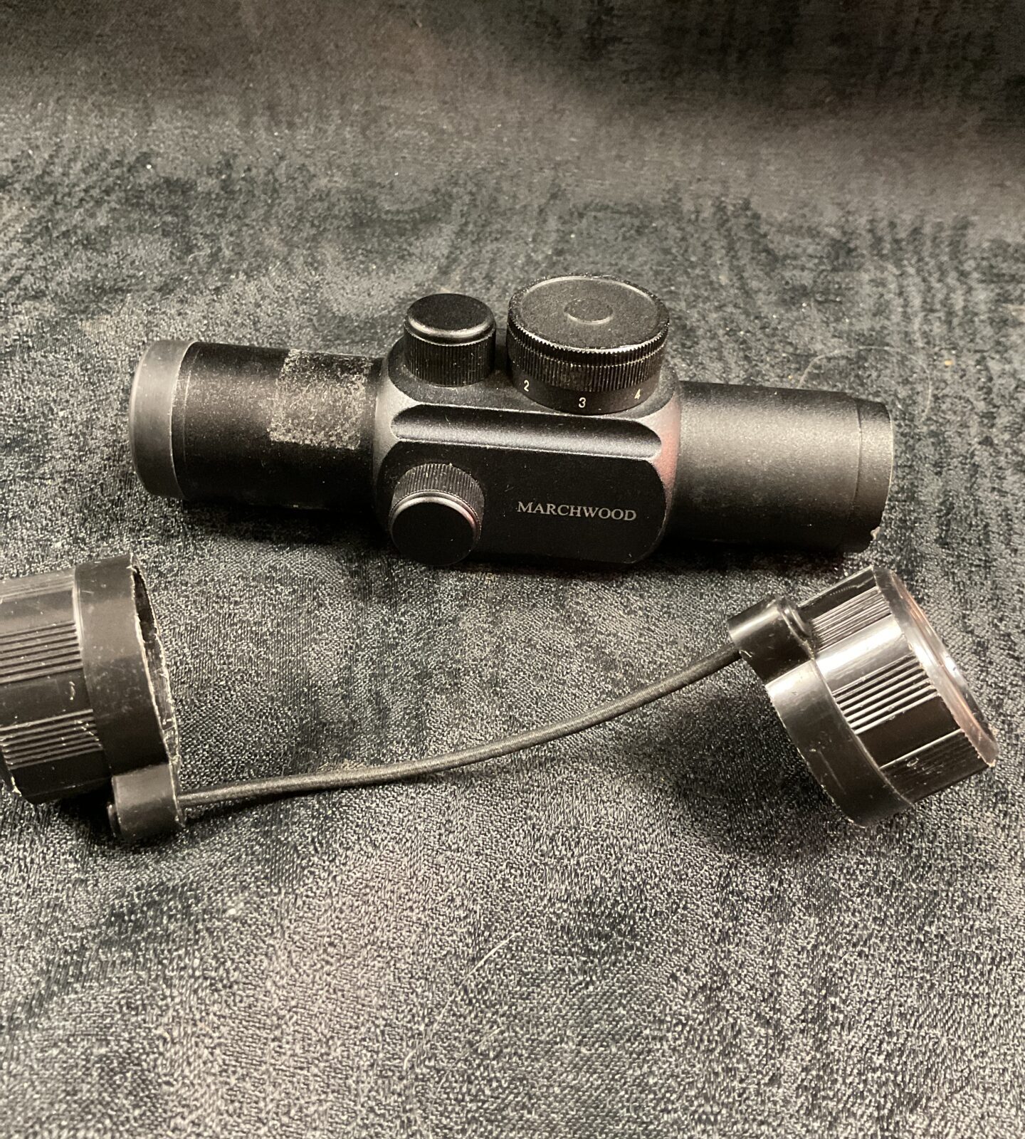 Front view of a Marchwood red dot sight with protective covers.