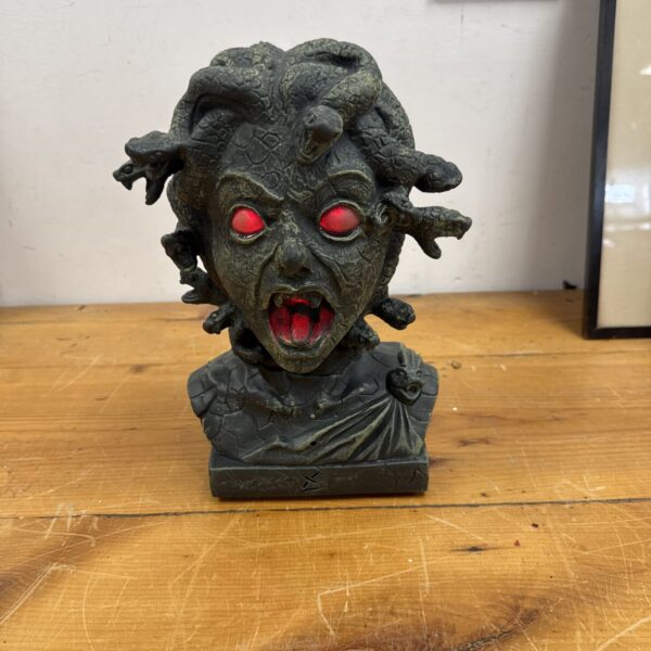 Detailed latex Medusa bust with illuminated eyes and moving snakes.