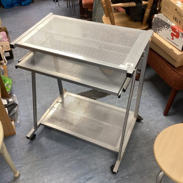 Perforated metal computer desk on caster wheels for mobile workstation.