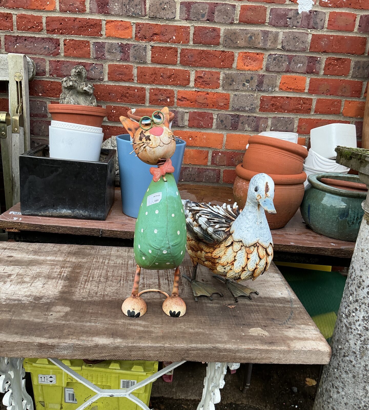 Colourful metal garden duck ornament in a garden setting.