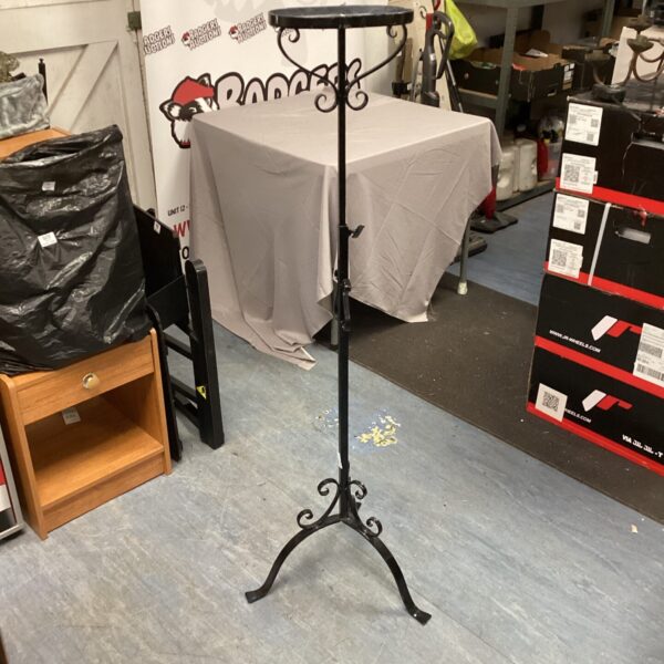 Adjustable metal pot stand with decorative wrought iron design.