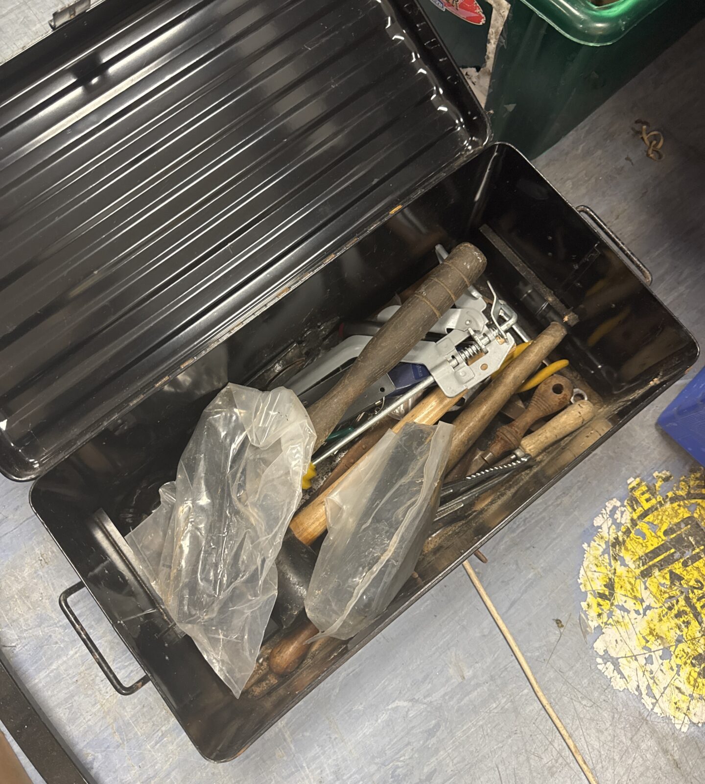 Metal tool storage box filled with assorted hand tools.