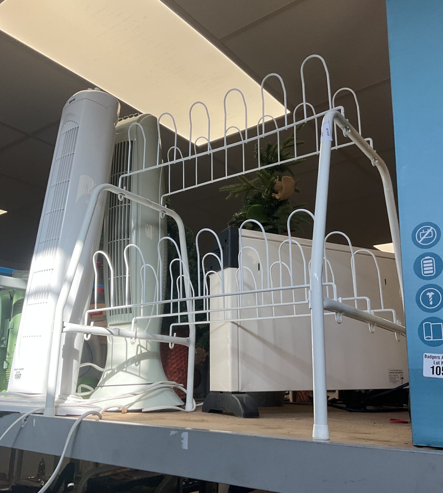 Metal wire shoe rack for organised shoe storage in a hallway.