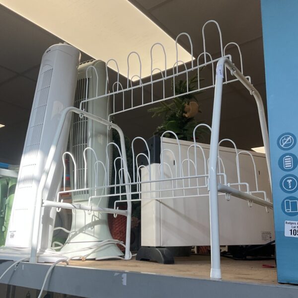 Metal wire shoe rack for organised shoe storage in a hallway.
