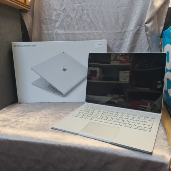 Silver Microsoft Surface Book 2-in-1 laptop, open on a table.