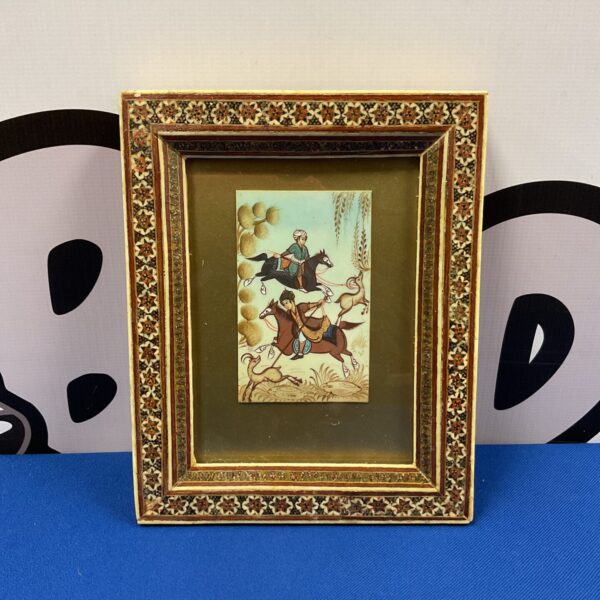 Antique Middle Eastern bone painting depicting a vibrant hunting scene.