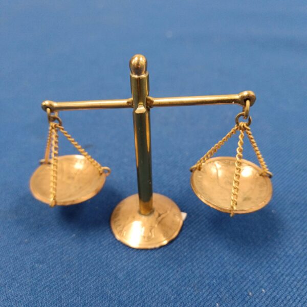 Close-up of miniature balance scales made from pennies.
