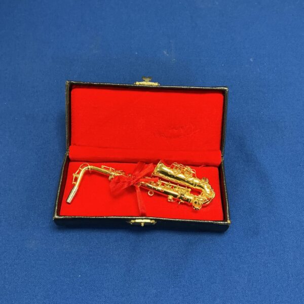 Detailed miniature metal saxophone in protective case.