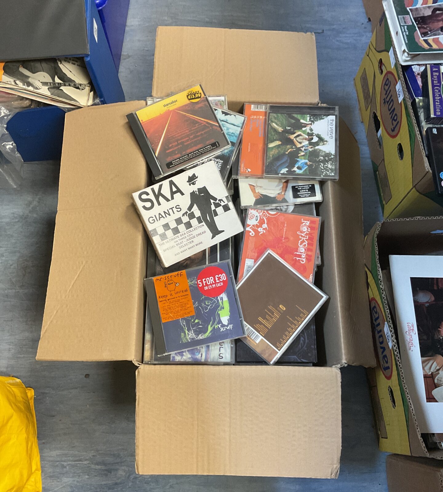 Large box filled with a mixed collection of compact discs.