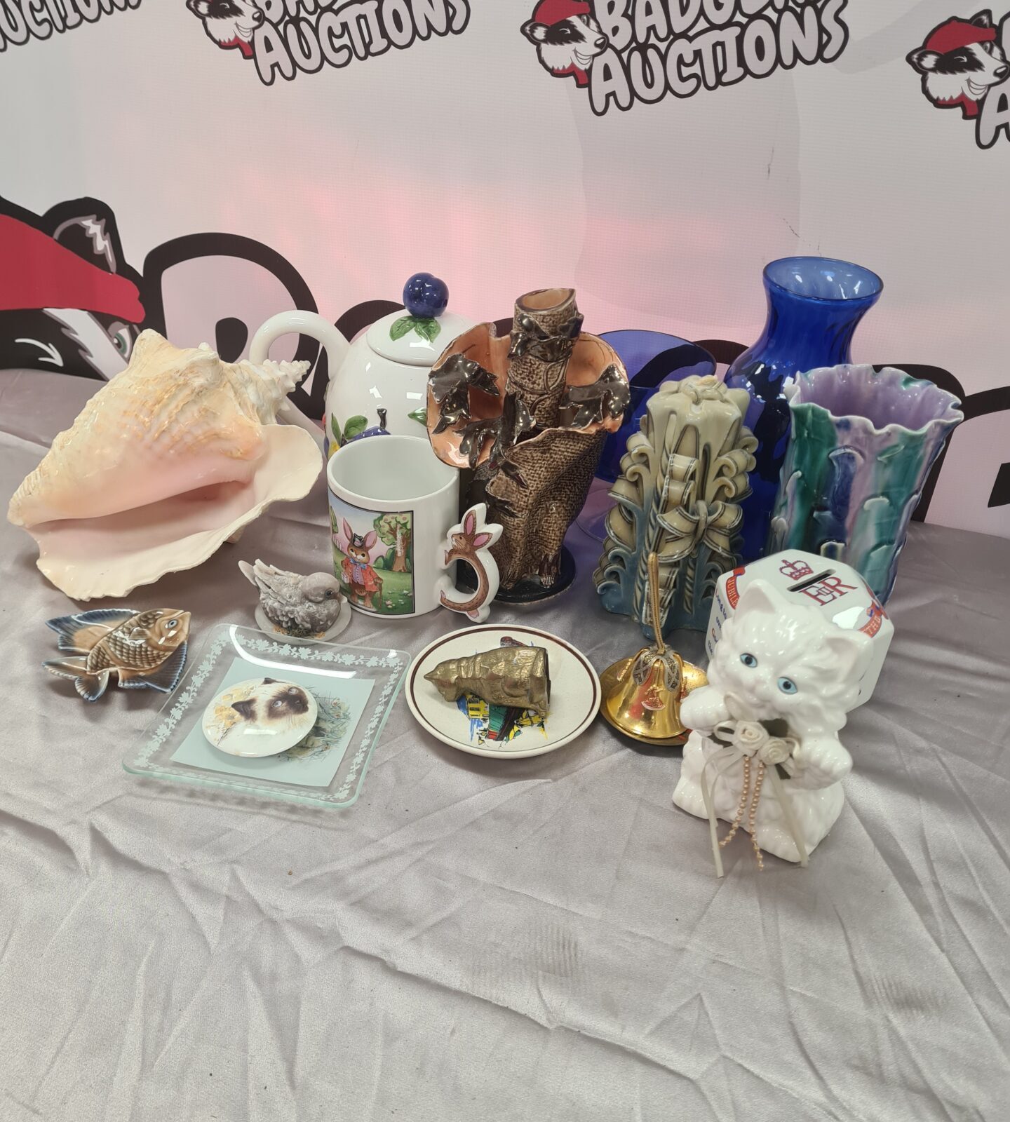 Mixed lot of vintage china and brass collectibles on display.
