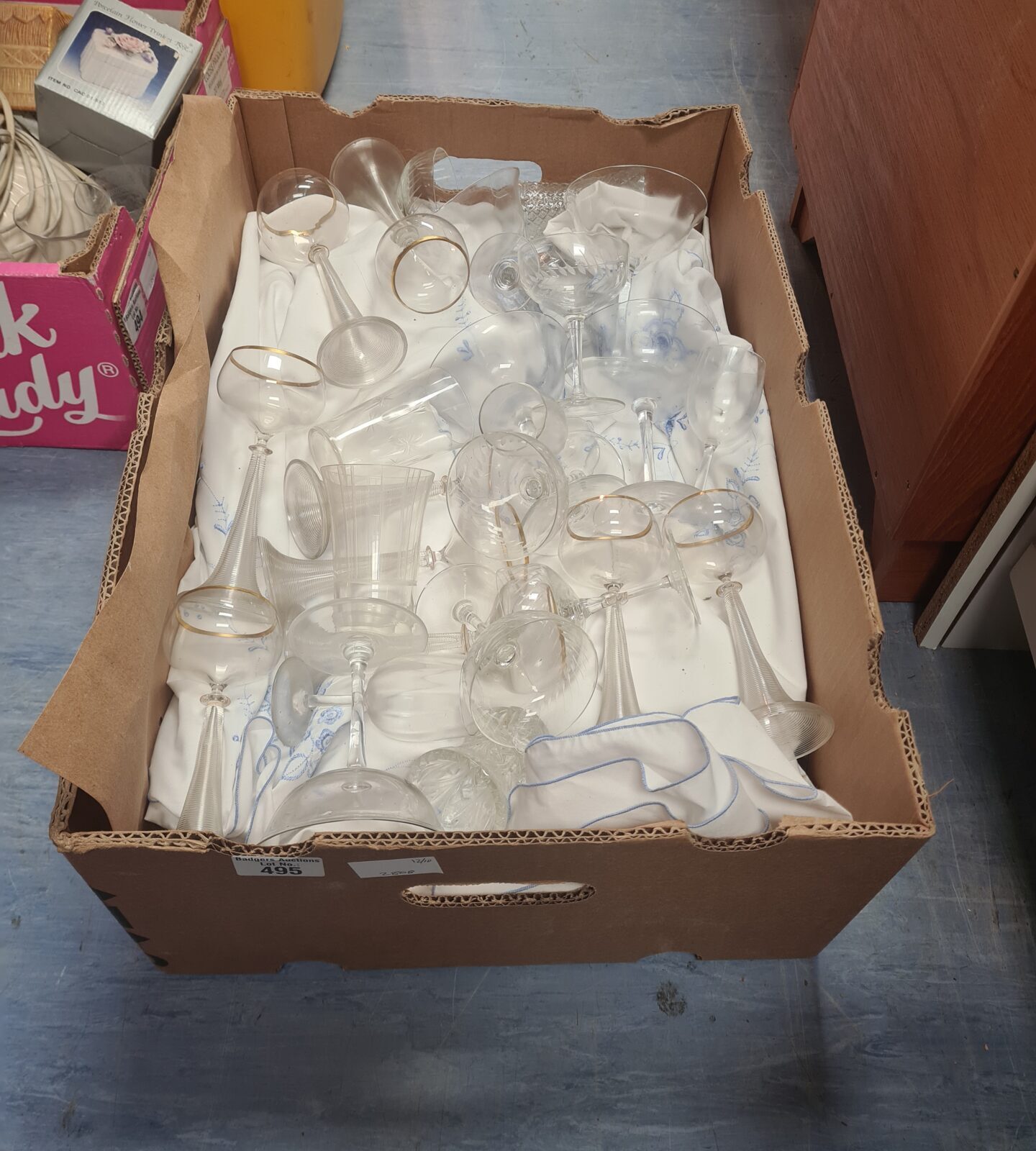 Mixed lot of cocktail and drinking glassware in a cardboard box.