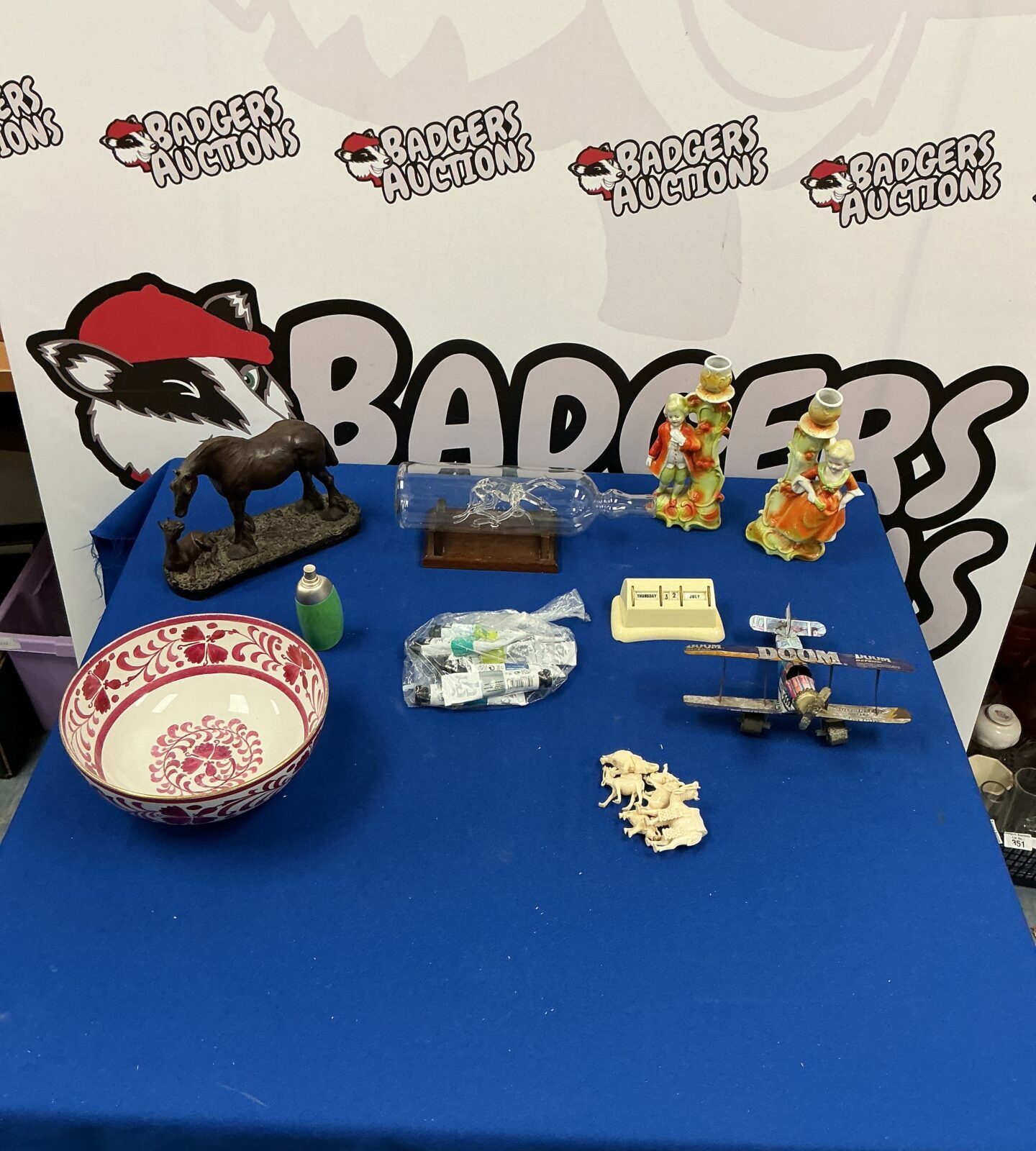 Mixed lot of vintage collectibles with Greyhound figurines in glass bottle.
