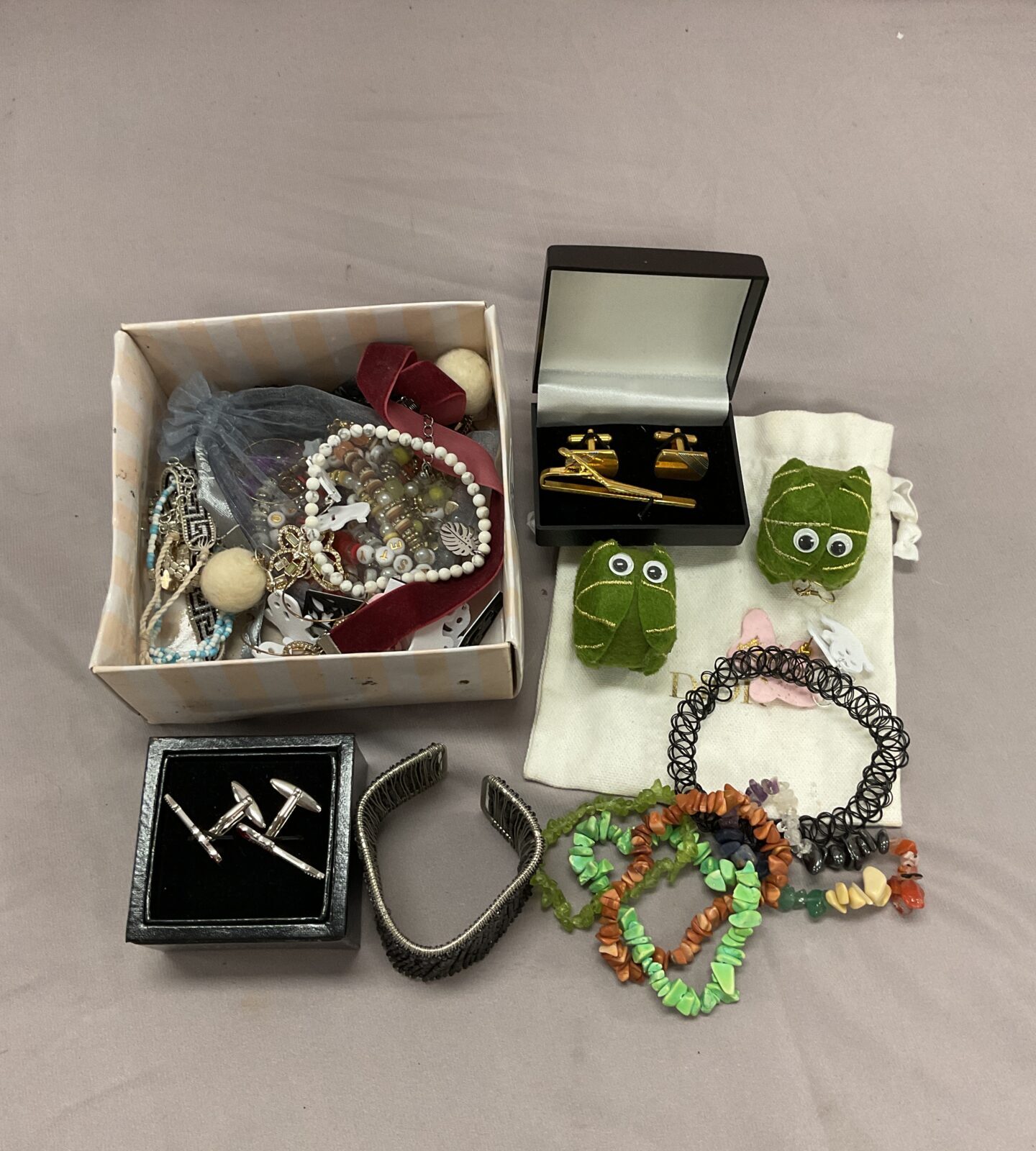 Tray of mixed jewellery including coral bracelets and Halloween earrings.