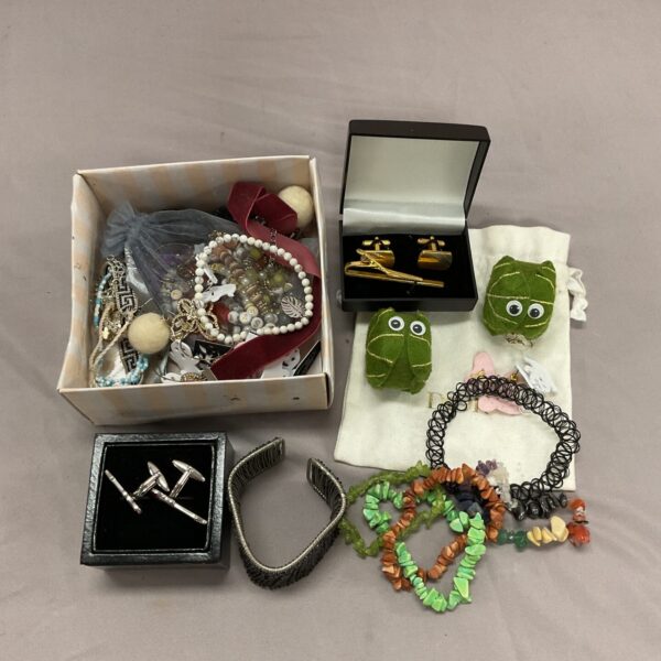 Tray of mixed jewellery including coral bracelets and Halloween earrings.