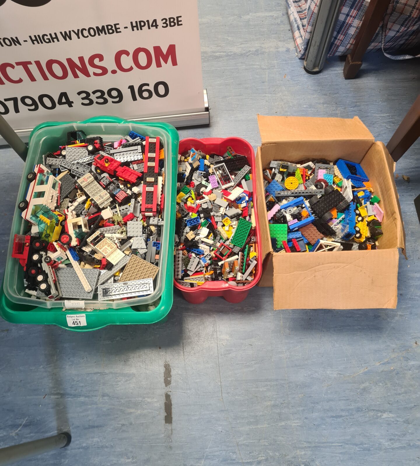 Three boxes filled with a large assortment of mixed Lego bricks.