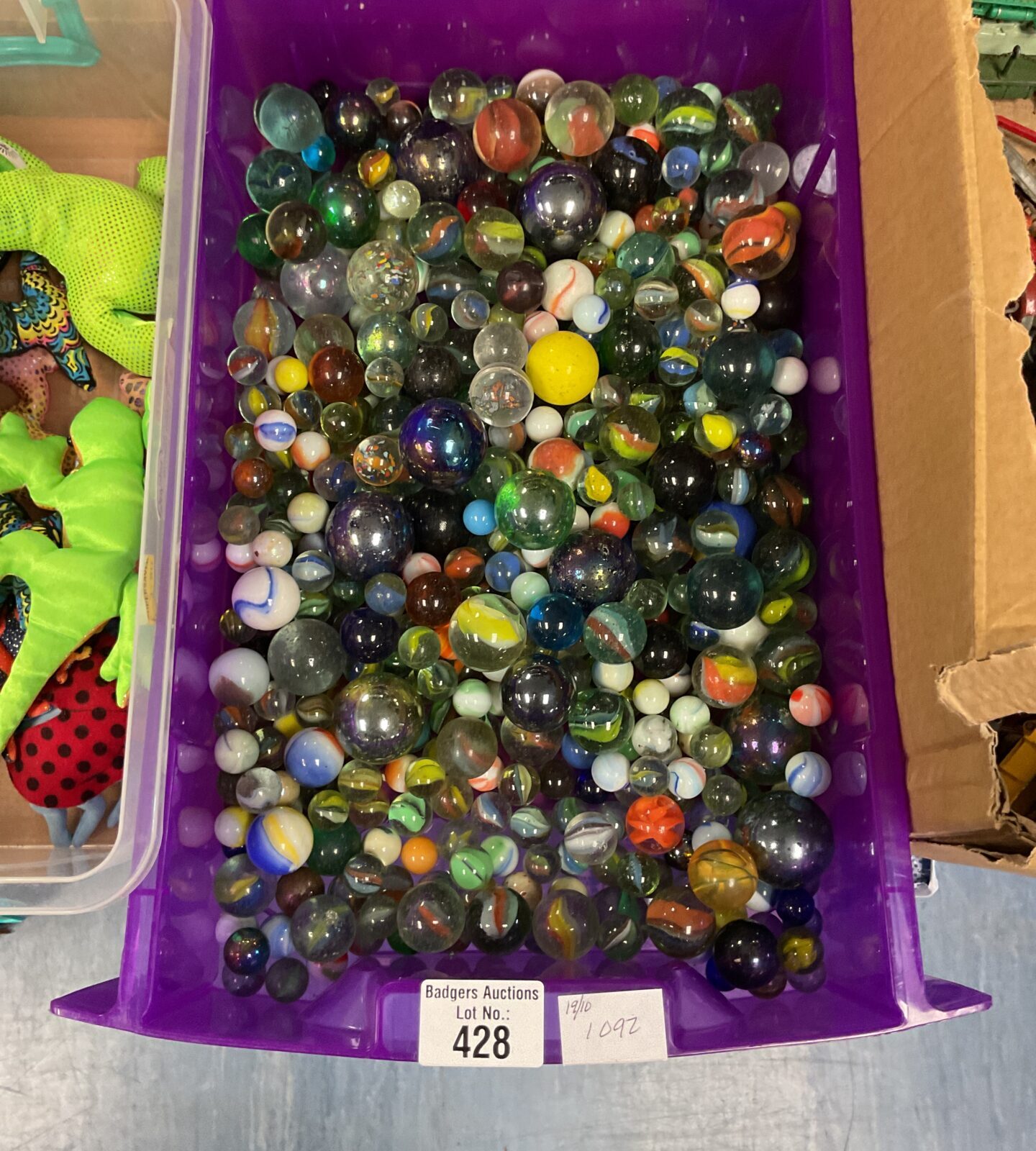 Colourful mixed marbles in a plastic container, vintage toy collection.