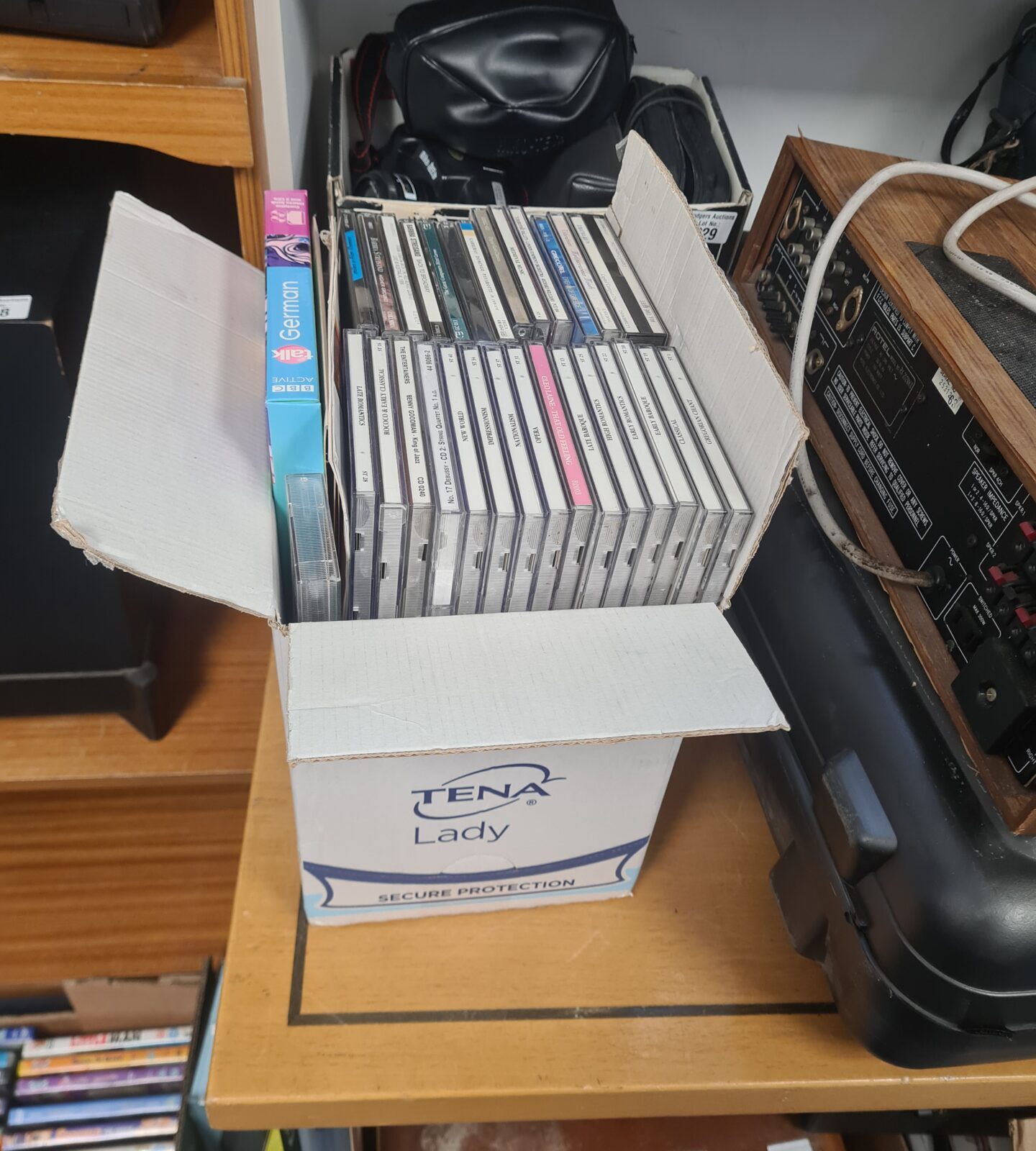 Mixed music CD lot in a cardboard box.