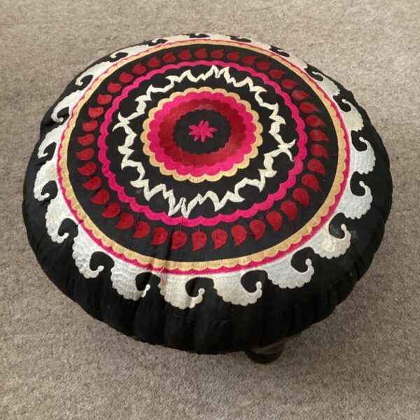 Vibrant embroidered Moroccan pouffe for comfortable floor seating.