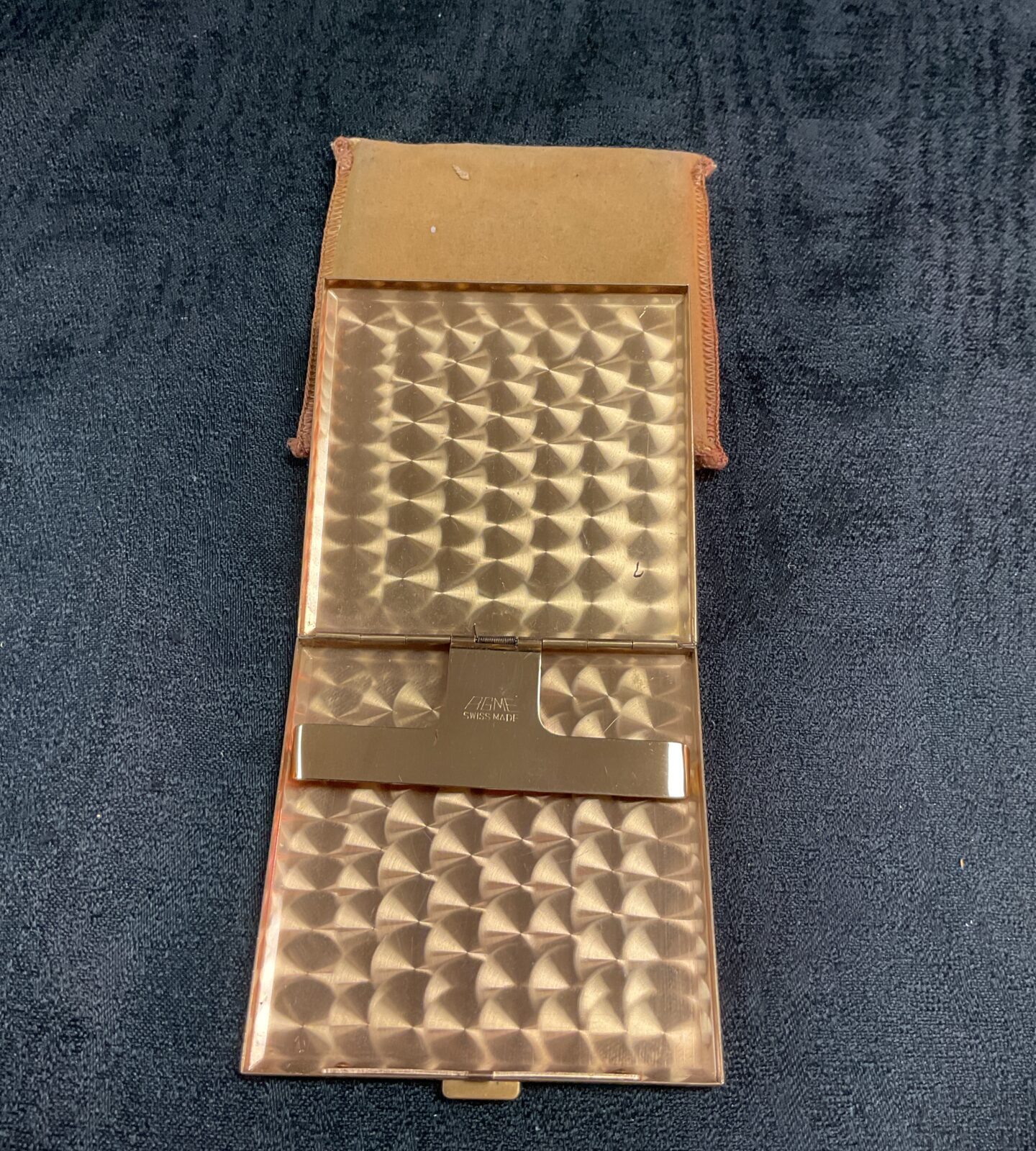 Closed vintage mother of pearl cigarette case on dark background.