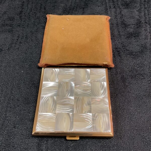 Open vintage mother of pearl cigarette case with brown lining.