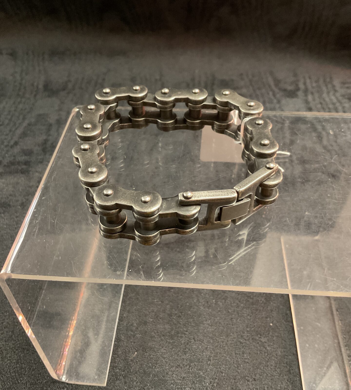Close-up of a rugged motorcycle chain bracelet.