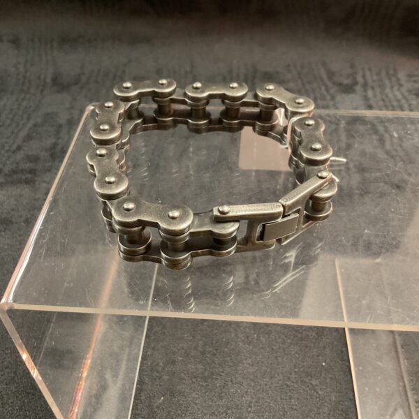 Close-up of a rugged motorcycle chain bracelet.