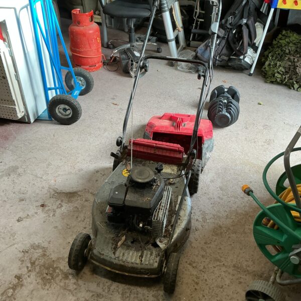 Used Mountfield petrol lawn mower in a garden setting.