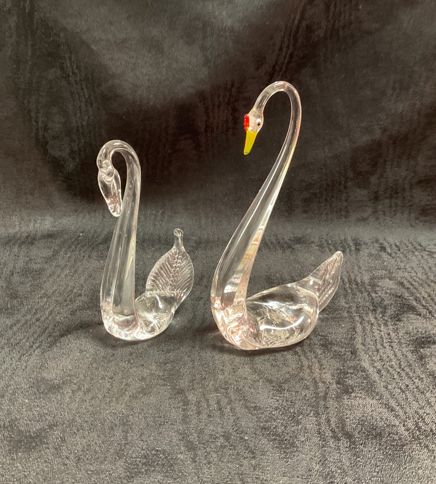 Elegant pair of vintage Murano glass swans on a dark background.