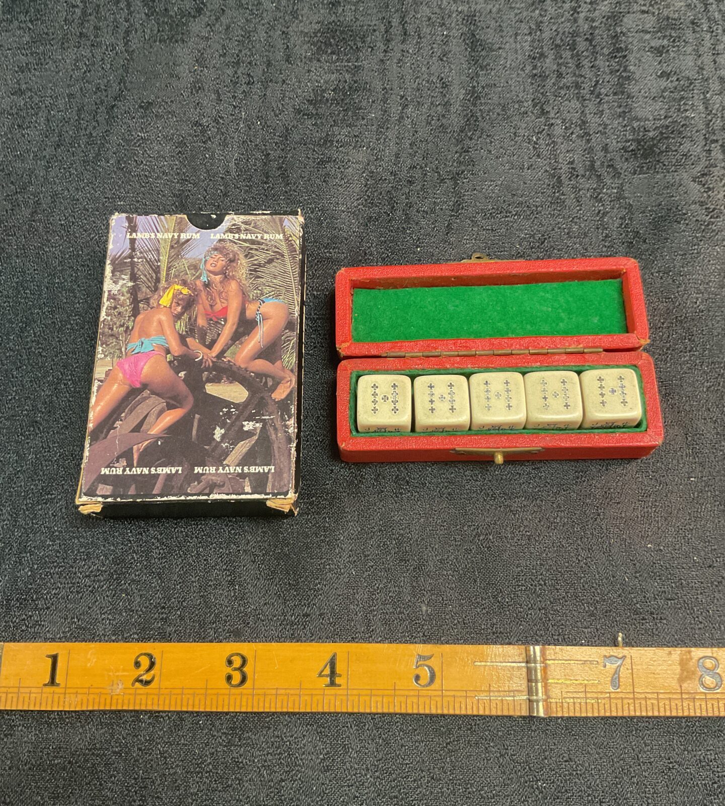 Vintage navy rum playing cards and poker dice set on display.