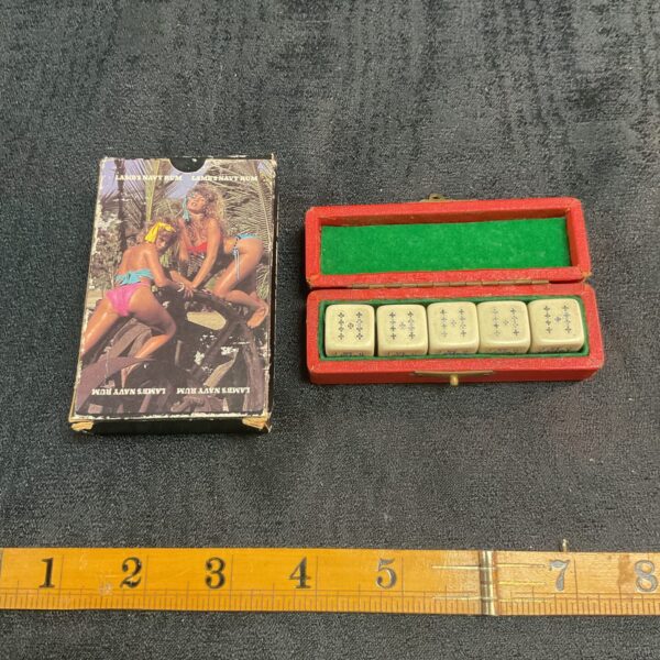 Vintage navy rum playing cards and poker dice set on display.