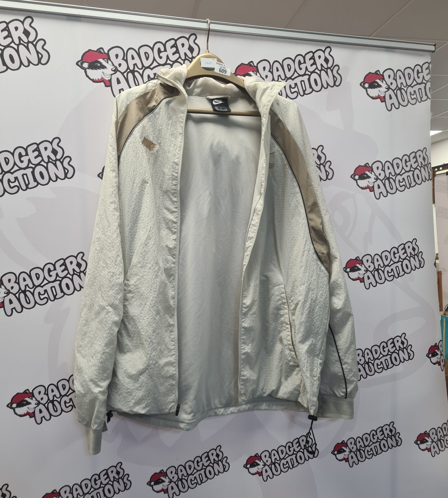 Front view of a Nike windbreaker jacket in grey.