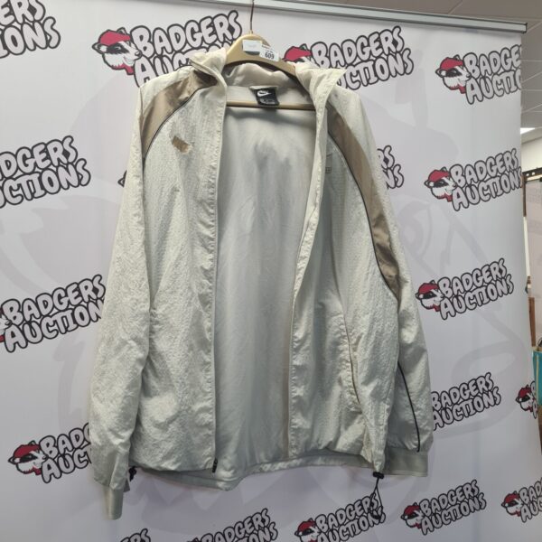 Front view of a Nike windbreaker jacket in grey.