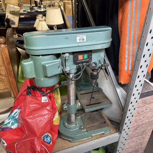 Vintage Nutool pillar drill in a workshop setting.