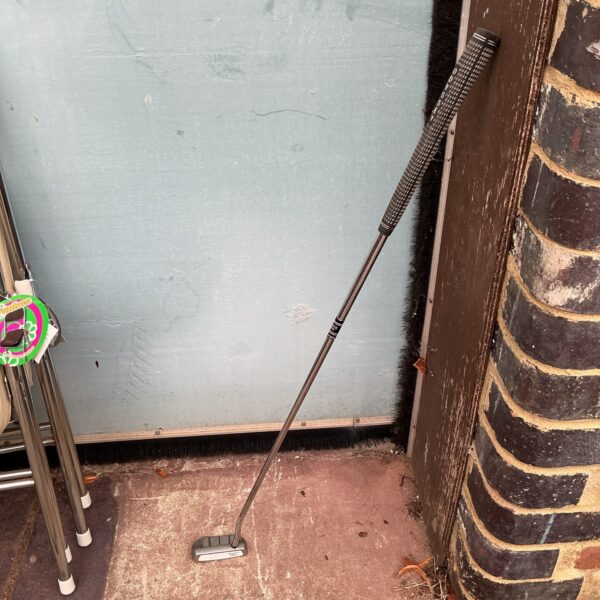 Odyssey White Hot putter leaning against a wall.