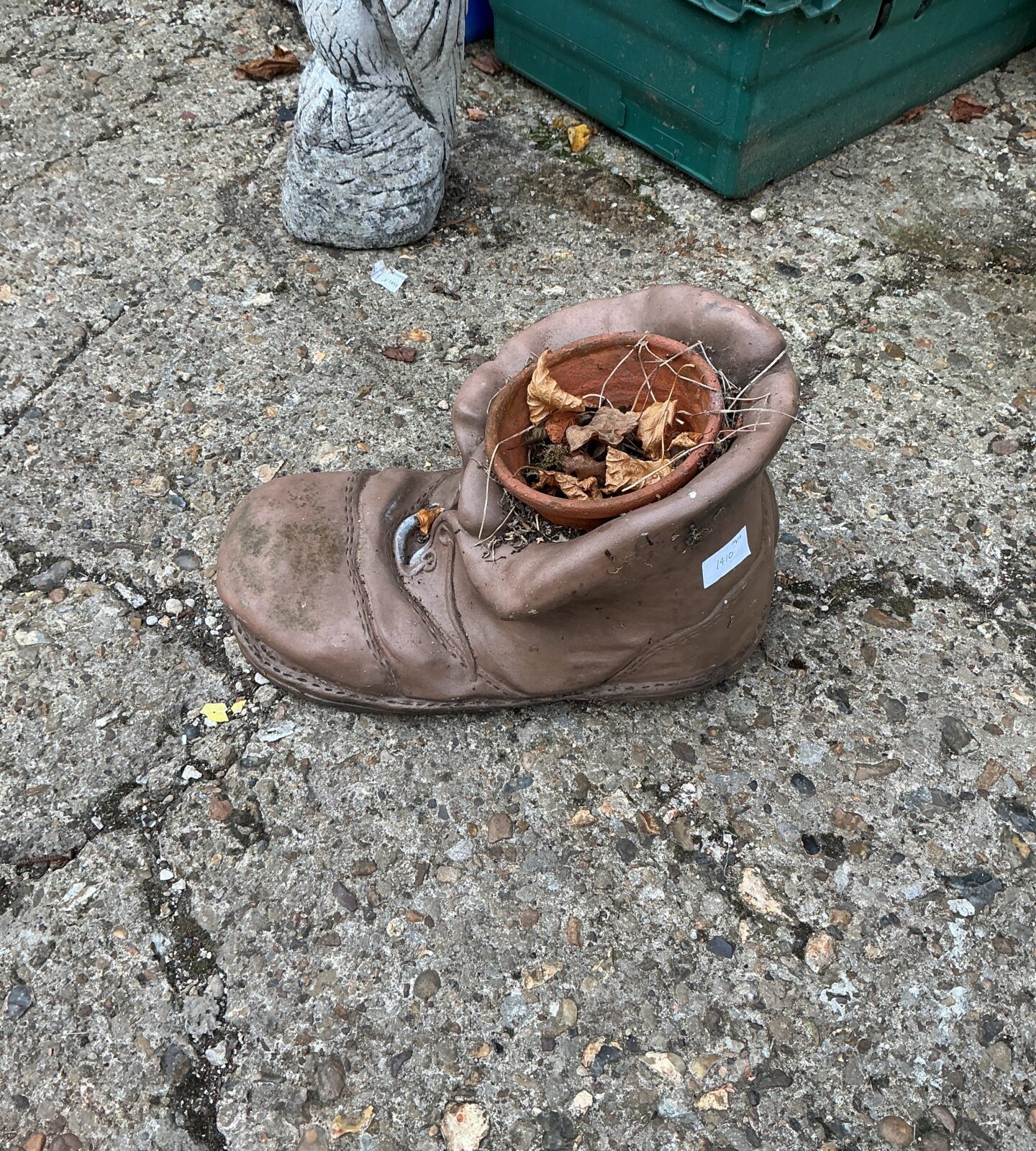 Rustic vintage leather boot planter in a garden setting.